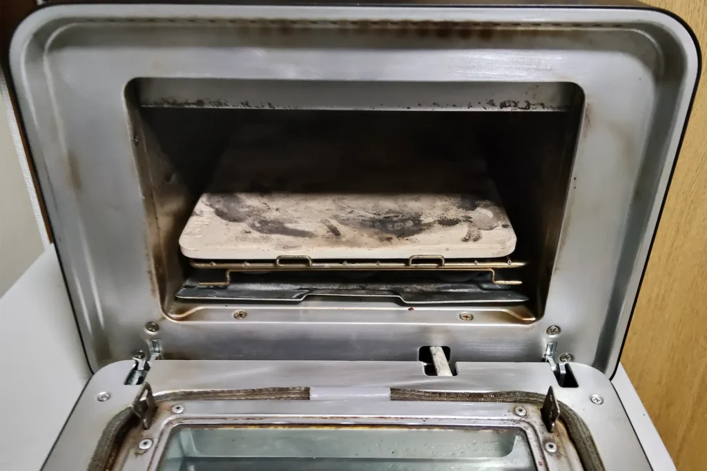 ENRO電気ピザ窯mini使用後の、庫内の煤汚れとストーンが汚れている様子