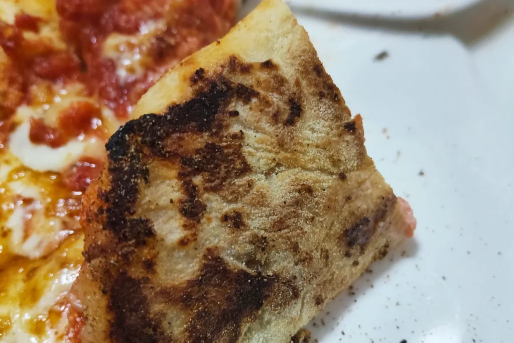 ENRO電気ピザ窯miniで焼いたピザの裏側を見た画像。しっかりと焦げ目がついて焼けている自家製ピザ。